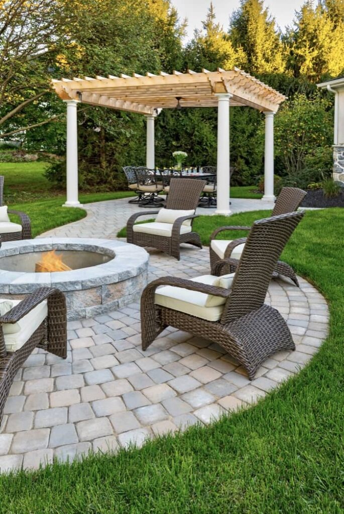 Patio installation includes paver designs that focus on a seating area surrounding a fire pit.
