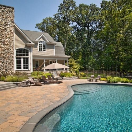 In-ground pool in backyard of a residential home on a sunny day
