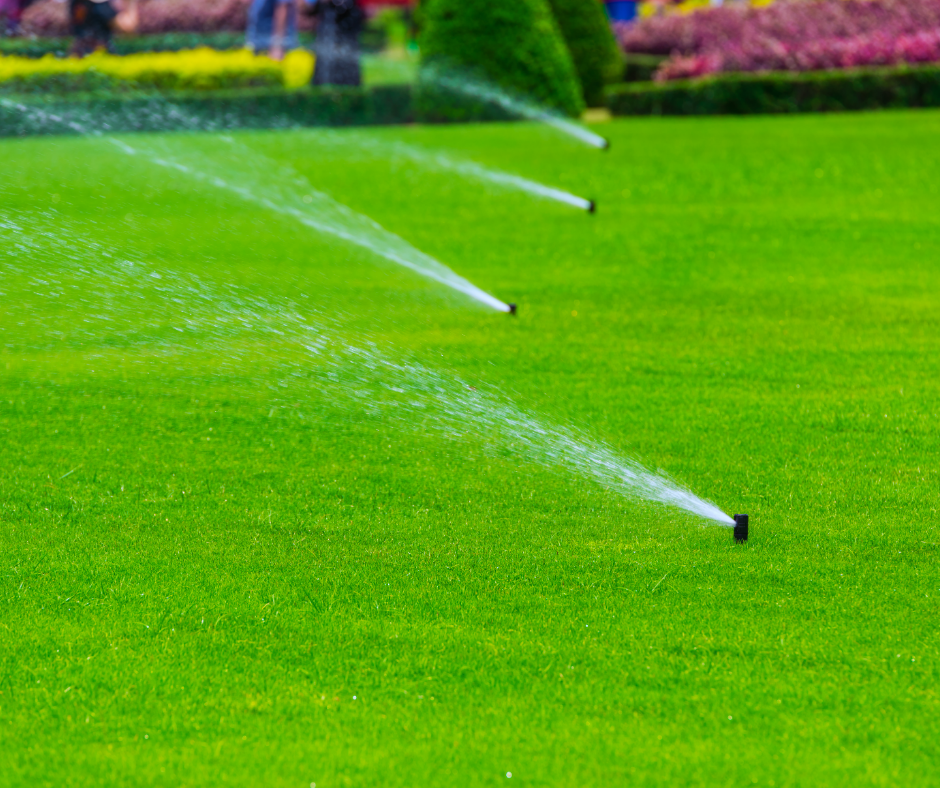 Irrigation system spraying water over green grass
