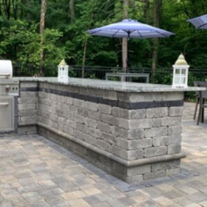 patio pavers and an outdoor kitchen in backyard residence